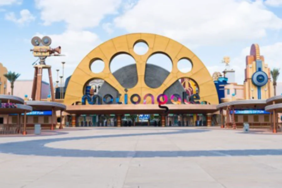 A grand, golden entrance gate at Dubai Parks and Resorts styled after a classic Hollywood film reel, welcoming visitors to the movie-themed attractions of Motiongate Dubai.