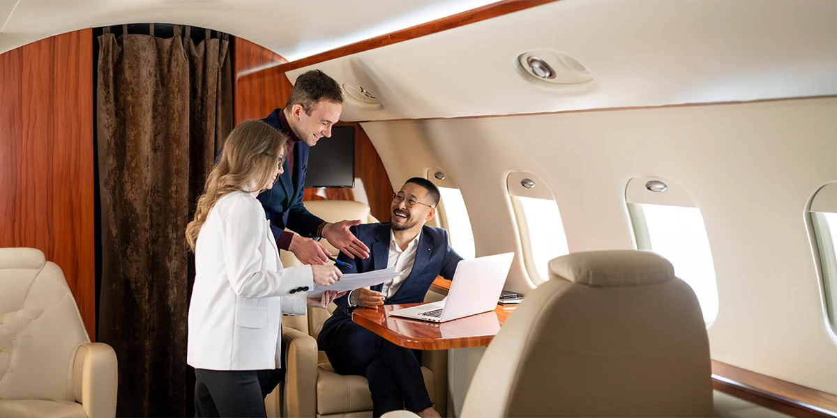 Business professionals conducting a meeting inside a private jet, highlighting premium executive travel services and efficient corporate travel planning for VIP business travelers.